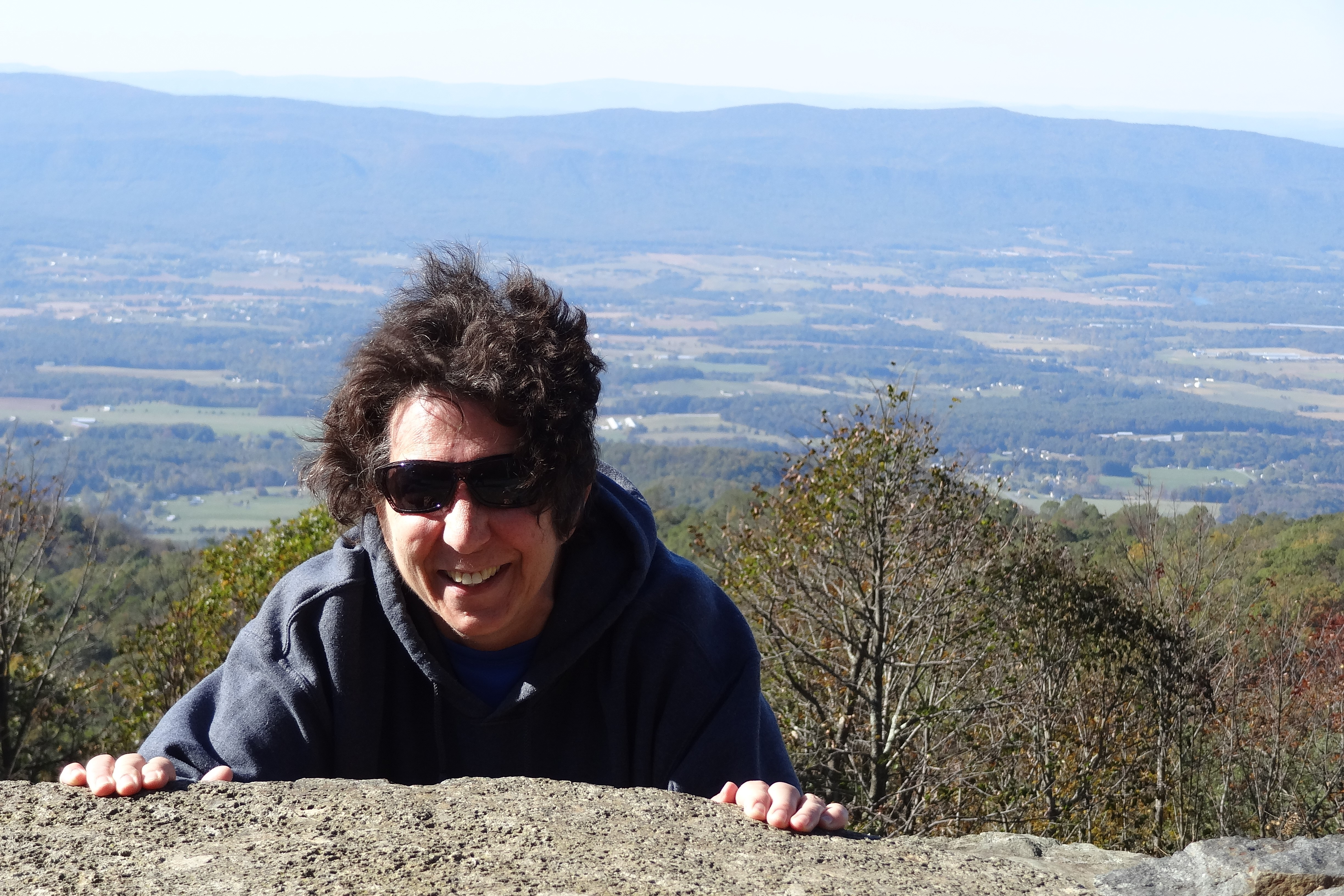 Picture of Marie behind wall on mountain overlook.