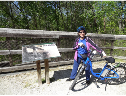 Marie with bike in front of sign Marie with bike in front of sign